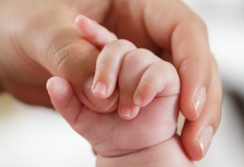 Baby greift nach Mutterhand